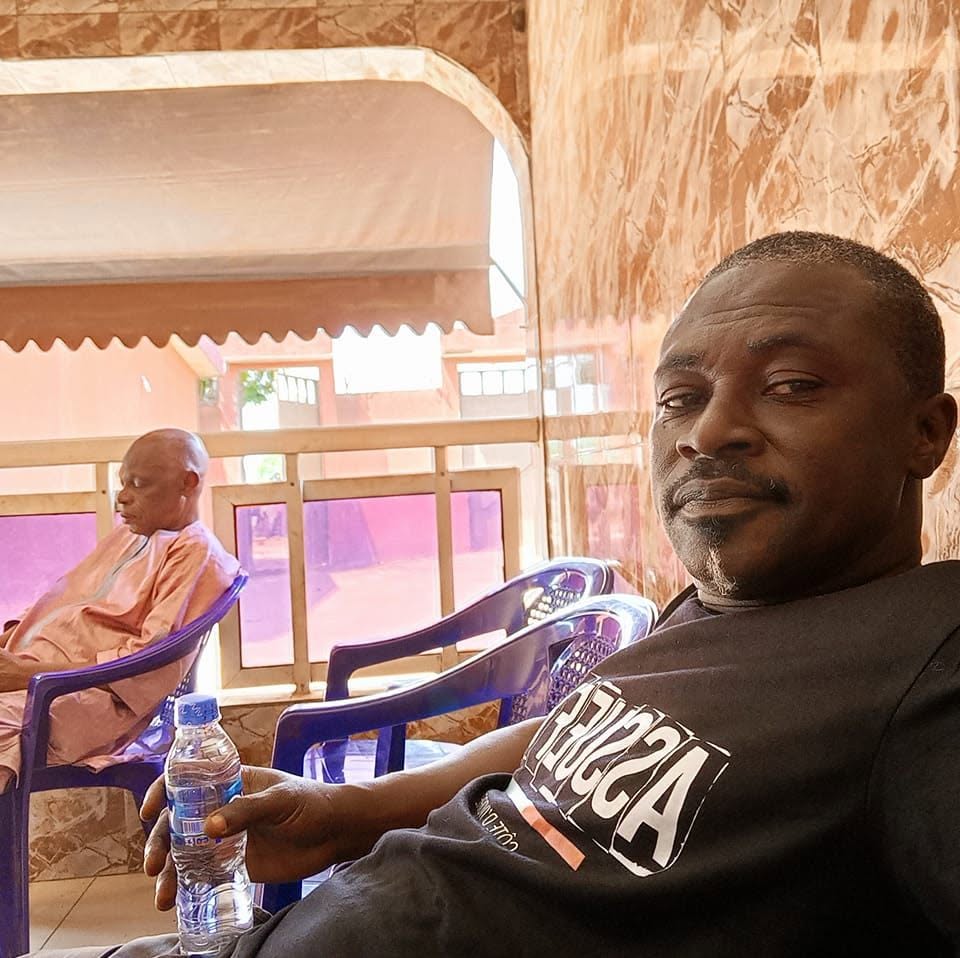 Portrait naturel de DJ Ice Brahima Kopa, assis en tee-shirt sombre, publié sur le profil Facebook Bouraman Ouattara.